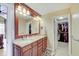 Double sink bathroom vanity with wood cabinets, granite counters, and a large mirror at 4754 Austin Trce, Zionsville, IN 46077