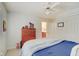 View of cozy bedroom showcases wooden dresser, ceiling fan, and hints of adjacent bathroom at 4754 Austin Trce, Zionsville, IN 46077