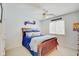 A cozy bedroom with a wooden bed frame, ceiling fan, and sports-themed decorations at 4754 Austin Trce, Zionsville, IN 46077
