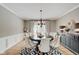 A formal dining room, featuring a round table with seating for six, complemented by hardwood flooring and elegant decor at 4754 Austin Trce, Zionsville, IN 46077