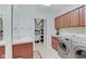 Well-equipped laundry room with cabinets, sink, shelving, and modern washer/dryer at 4754 Austin Trce, Zionsville, IN 46077
