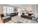 Open-concept living room featuring hardwood floors, large windows, and comfortable seating area with view to kitchen at 4754 Austin Trce, Zionsville, IN 46077