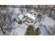 An aerial view shows a home and a snowy landscape with a pool and a sunroom at 4859 W 150 N, Greenfield, IN 46140