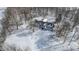 An aerial view shows the home and a snowy landscape with mature trees and landscaping at 4859 W 150 N, Greenfield, IN 46140