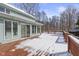 A back deck offers a charming space for outdoor entertaining and views to the snow covered backyard and trees at 4859 W 150 N, Greenfield, IN 46140