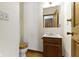 Small bathroom with a wooden vanity, mirror, toilet, and hardwood floors at 4859 W 150 N, Greenfield, IN 46140