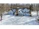 Charming two-story home with light blue siding and a stone chimney surrounded by a snow-covered yard at 4859 W 150 N, Greenfield, IN 46140