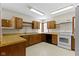 Well-lit kitchen featuring wooden cabinets, laminate countertops, and modern appliances for convenience at 4859 W 150 N, Greenfield, IN 46140