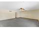 Open living room with a ceiling fan and light fixture with grey carpeting at 4859 W 150 N, Greenfield, IN 46140
