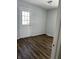 Bedroom with laminate flooring, gray paint, and a back door leading to the yard at 5139 S Keystone Ave, Indianapolis, IN 46227