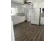 Traditional kitchen with white cabinets, laminate flooring, and view of the entry to the laundry room at 5139 S Keystone Ave, Indianapolis, IN 46227