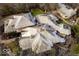 Aerial view of a sprawling residence highlighting its unique roofline, mature trees, and landscaped surroundings at 5400 W Deer Run Ct, Muncie, IN 47304