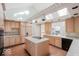 Well-lit kitchen boasts custom cabinets, an island cooktop, and bright countertops at 5400 W Deer Run Ct, Muncie, IN 47304
