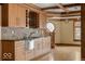 Stylish kitchenette area features wood cabinets, mosaic backsplash, sink, and access to adjacent room at 5400 W Deer Run Ct, Muncie, IN 47304