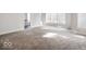 Expansive living room featuring neutral carpeting and ample natural light at 5400 W Deer Run Ct, Muncie, IN 47304