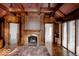 Cozy living room highlighting a stone fireplace, custom woodwork, and large windows at 5400 W Deer Run Ct, Muncie, IN 47304