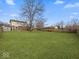 Spacious backyard featuring a large lawn, mature trees, and a wooden fence providing privacy at 5415 Honey Comb Ln, Indianapolis, IN 46221