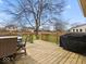 Inviting wooden deck featuring an outdoor dining set, grill, and railings for relaxing or entertaining at 5415 Honey Comb Ln, Indianapolis, IN 46221