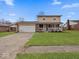 Charming two-story home with a covered front porch, attached garage, and well-manicured lawn at 5415 Honey Comb Ln, Indianapolis, IN 46221