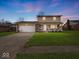 Charming two-story home with a covered front porch, attached garage, and well-manicured lawn at 5415 Honey Comb Ln, Indianapolis, IN 46221