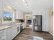 Updated kitchen with stainless steel refrigerator, white cabinets, and wood-look flooring at 5415 Honey Comb Ln, Indianapolis, IN 46221