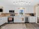 Bright kitchen with stainless steel appliances, white cabinets, and wood-look flooring at 5415 Honey Comb Ln, Indianapolis, IN 46221