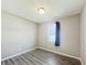 Cozy bedroom featuring wood-look flooring, neutral walls, and natural light from a window with a blue curtain at 673 Ballycastle Ct, Pendleton, IN 46064