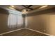 Neutral bedroom showcasing trey ceiling with fan, hardwood floors, and large window with white curtains at 673 Ballycastle Ct, Pendleton, IN 46064