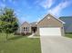 Charming single-Gathering home with brick exterior, manicured lawn, and two-car garage on a sunny day at 673 Ballycastle Ct, Pendleton, IN 46064
