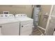 Laundry room featuring white washer and dryer, water heater, and shelf at 673 Ballycastle Ct, Pendleton, IN 46064