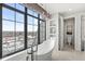 Chic bathroom with a modern tub under a window offering city views and a connected toilet room at 720 S Rangeline Rd # 601, Carmel, IN 46032
