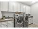 Well-organized laundry room with ample cabinet space, countertop and modern machines at 720 S Rangeline Rd # 601, Carmel, IN 46032