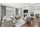 Bright living room with a fireplace, large windows, elegant furniture, and dark hardwood floors at 720 S Rangeline Rd # 601, Carmel, IN 46032