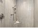 Tiled shower stall featuring sleek fixtures, ample shelving, and a comfortable shower seat at 720 S Rangeline Rd # 601, Carmel, IN 46032