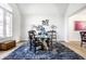 Dining room with hardwood floors and a shag rug boasts unique decor and a glass table with a statement design at 8845 Otter Cove Cir, Indianapolis, IN 46236