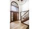 Grand foyer with a staircase, large window, and hardwood floors, showcasing the home's architectural details at 8845 Otter Cove Cir, Indianapolis, IN 46236