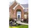 Charming brick home entrance featuring an arched doorway, elegant landscaping, and a welcoming pathway at 8845 Otter Cove Cir, Indianapolis, IN 46236