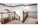 Hallway with wood railing, white walls, and a chandelier with a large window offering natural light at 8845 Otter Cove Cir, Indianapolis, IN 46236