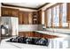 A well-appointed kitchen with wooden cabinets, stainless steel appliances, and a central island with a cooktop at 8845 Otter Cove Cir, Indianapolis, IN 46236