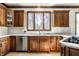 Classic kitchen with dark cabinets, a large window over the sink, and stainless steel appliances at 8845 Otter Cove Cir, Indianapolis, IN 46236