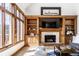 Bright living room boasts a fireplace with built-in shelves, large windows, and hardwood floors throughout at 8845 Otter Cove Cir, Indianapolis, IN 46236