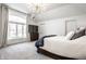 Spacious main bedroom featuring a large window, plush carpet, and modern decor with a TV for relaxing evenings at 8845 Otter Cove Cir, Indianapolis, IN 46236