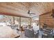 Relaxing covered deck featuring wood ceiling, fan, seating, and outdoor table, perfect for entertaining on snowy days at 925 Forest Dr, Anderson, IN 46011