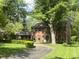 Two-story brick home with mature trees, manicured lawn, and long blacktop drive at 925 Forest Dr, Anderson, IN 46011