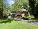 A two-story brick house with mature trees, a well-manicured lawn, and a long driveway at 925 Forest Dr, Anderson, IN 46011