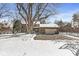 Classic brick home with snow-covered roof and spacious driveway, complemented by a mature tree and well-maintained yard at 925 Forest Dr, Anderson, IN 46011