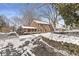 Charming brick two-story home featuring a covered porch, manicured landscaping, and a snow-covered front yard at 925 Forest Dr, Anderson, IN 46011