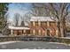 Traditional brick home with snow, a manicured lawn, and mature trees, offering classic charm and curb appeal at 925 Forest Dr, Anderson, IN 46011
