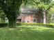 Two-story brick home with mature trees, a landscaped yard, and manicured shrubs at 925 Forest Dr, Anderson, IN 46011