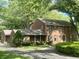 Charming two-story brick home with mature trees, landscaped yard, and covered porch at 925 Forest Dr, Anderson, IN 46011